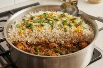 Best Homemade Spicy Biryani Recipe – Layering fried onions, mint leaves, and basmati rice over chicken masala for dum