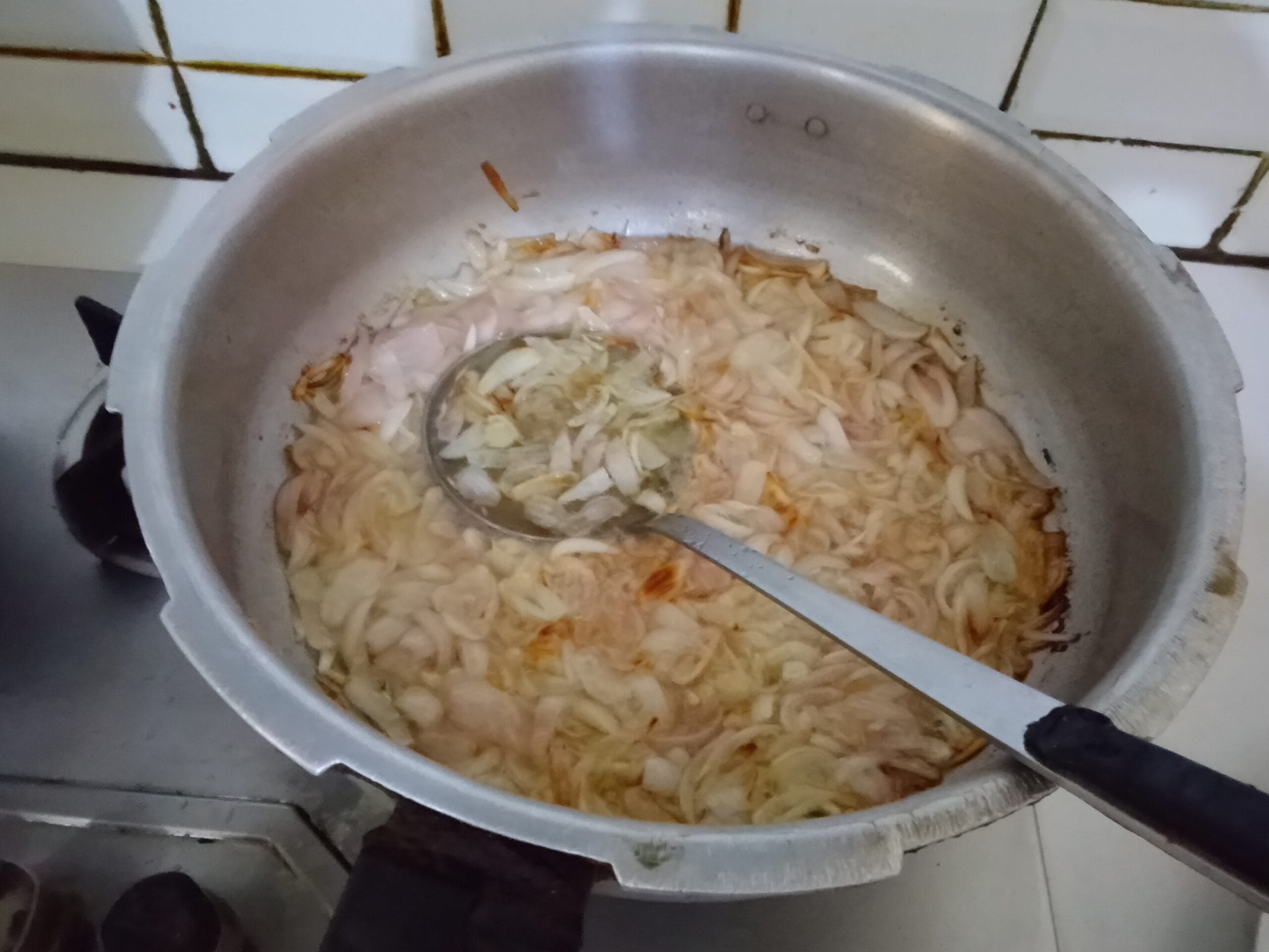 Best Homemade Spicy Biryani Recipe – Frying sliced onions to golden brown for layering and garnishing