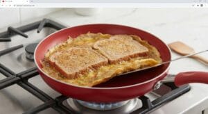 A vibrant red non-stick pan on a gas stovetop over a medium flame, with melting butter coating the surface. From above, a frothy, yellow egg mixture, speckled with finely chopped red bell peppers and green onions, is being poured evenly across the pan to cook the base of an Easy Healthy Breakfast Recipes