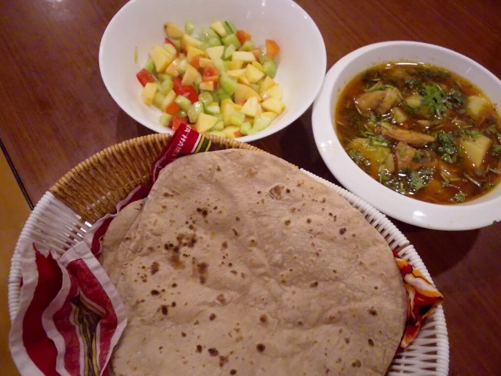 Final serving of delicious Aloo Chicken Recipe garnished with fresh coriander and green chilies