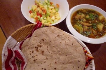 Final serving of delicious Aloo Chicken Recipe garnished with fresh coriander and green chilies