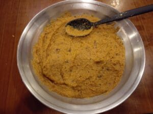 Cooling and dividing cooked onion masala into two equal halves on a tray for Masala Bharre Karele recipe